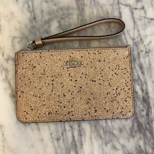 Small gold sparkly coach clutch